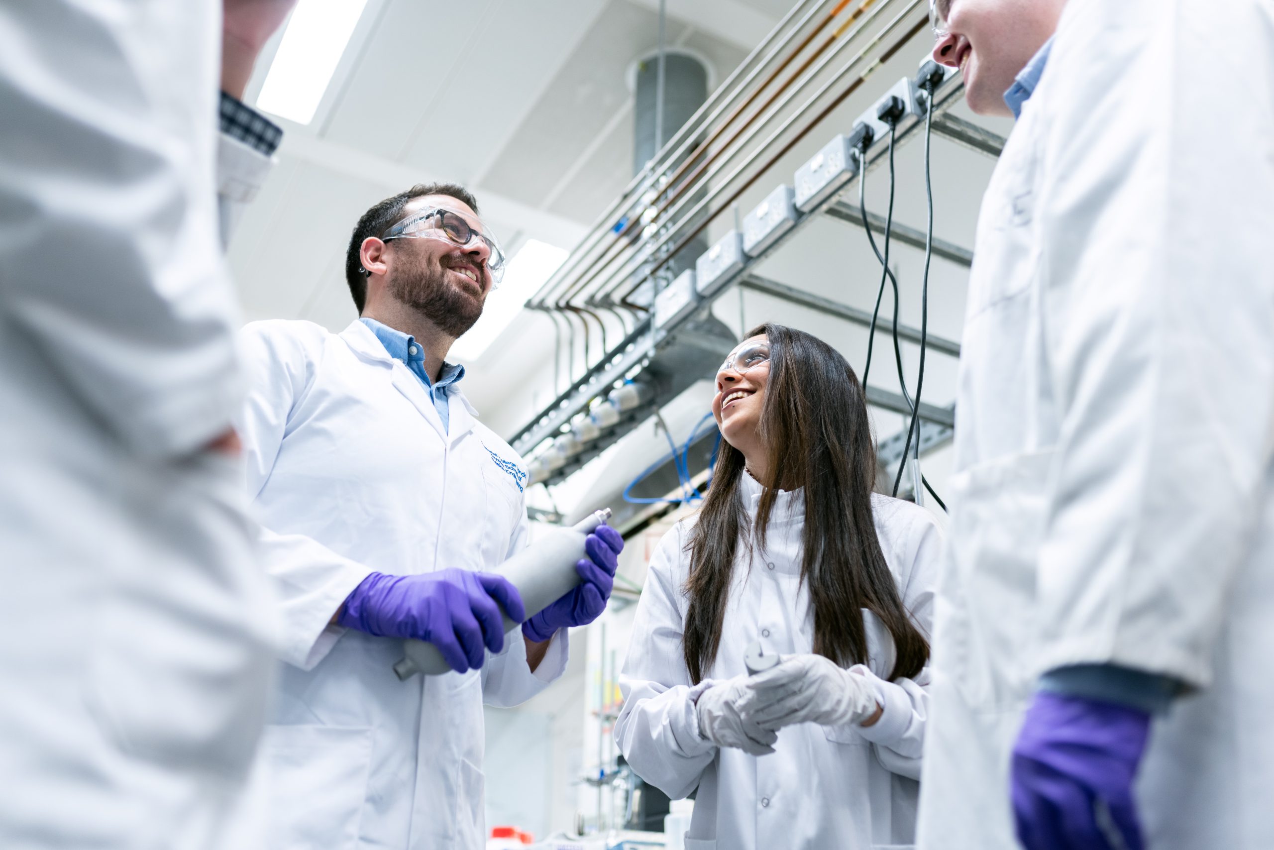 Fotografia de um grupo de cientistas conversando dentro de uma empresa