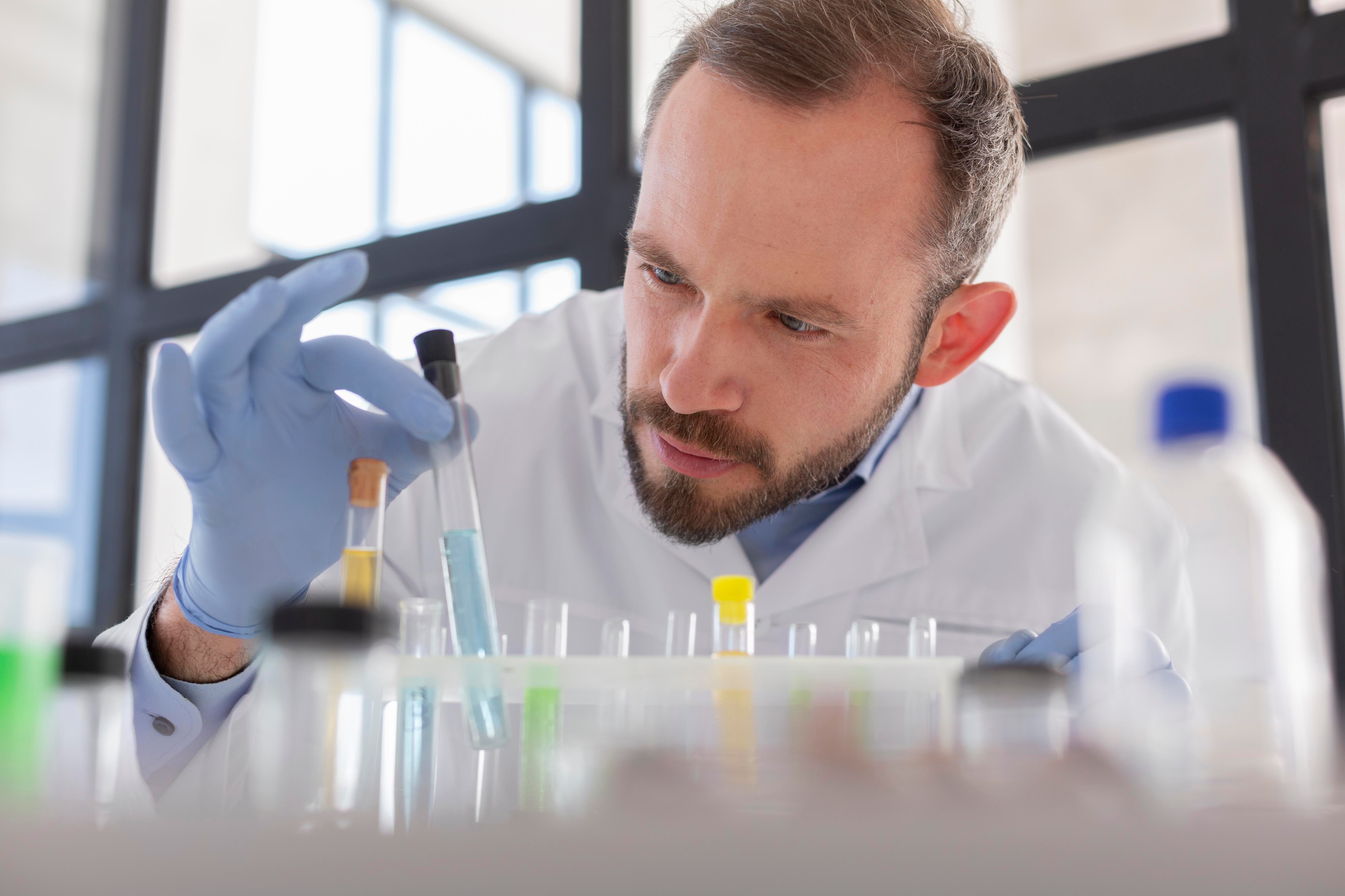 close-up-scientist-looking-tube