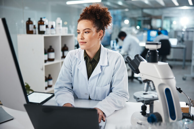 Cientista mexendo em sistema LIMS em uso em laboratório, mostrando automação de processos, rastreabilidade de amostras e indicadores de desempenho em tempo real.