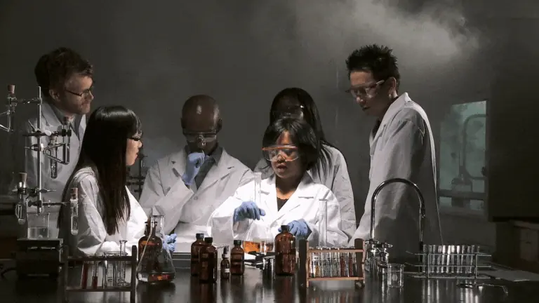 Equipe de cientistas reunida em bancada analisando reagentes, gestão de fornecedores em laboratórios.
