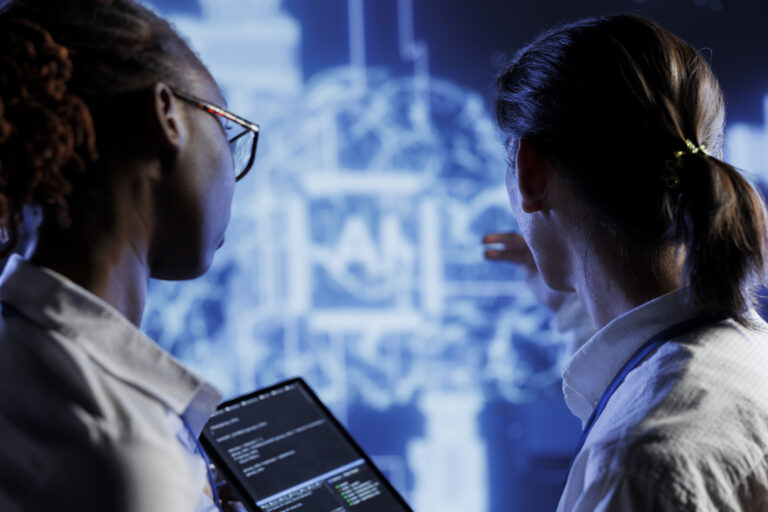 Duas profissionais analisam dados laboratoriais em uma tela digital, com tecnologia e IA ao fundo.